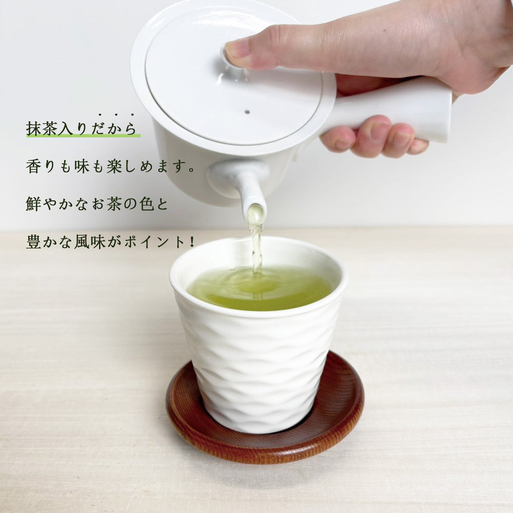 抹茶入り煎茶を白い湯のみに注ぐ様子。鮮やかな緑の色合い